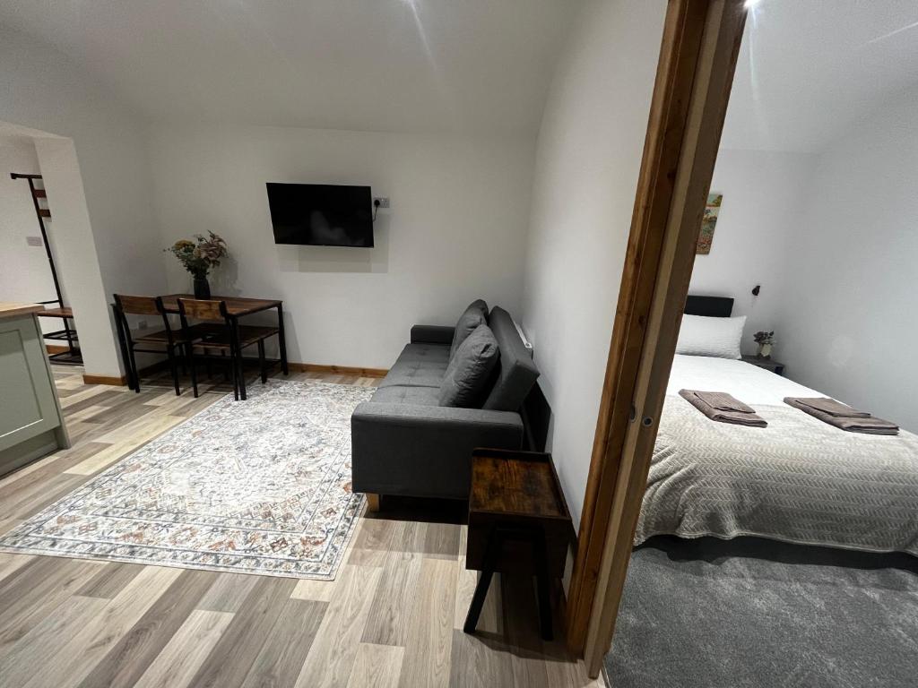 a living room with a couch and a bed at Small home in Llanfairpwll in Llanfairpwllgwyngyll