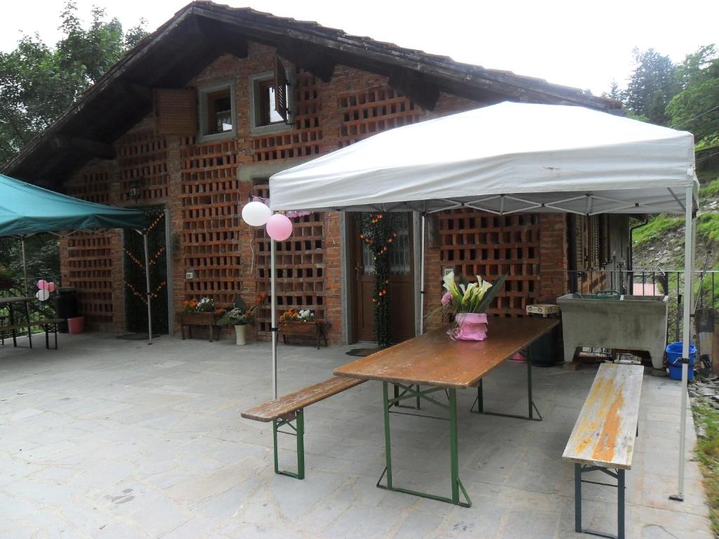 una mesa de picnic bajo una sombrilla frente a un edificio en Agriturismo La Buca, en Cutigliano