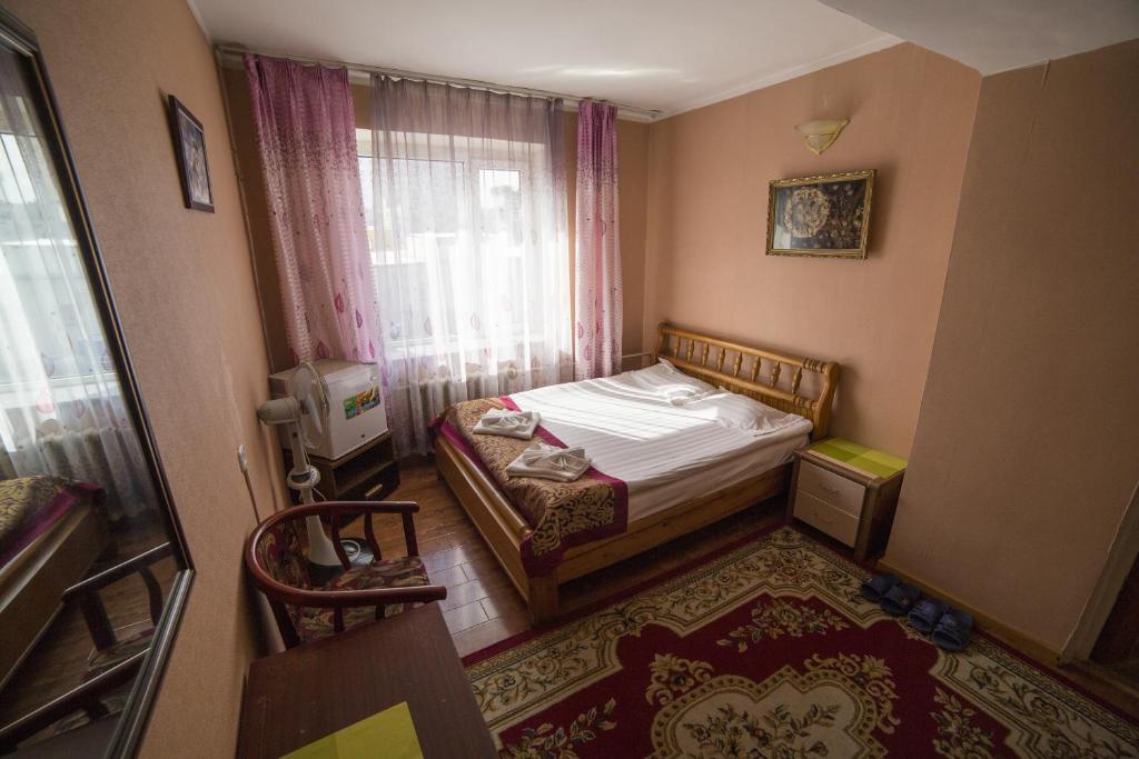 een kleine slaapkamer met een bed en een raam bij Danista Nomads Tour Hostel in Ulaanbaatar
