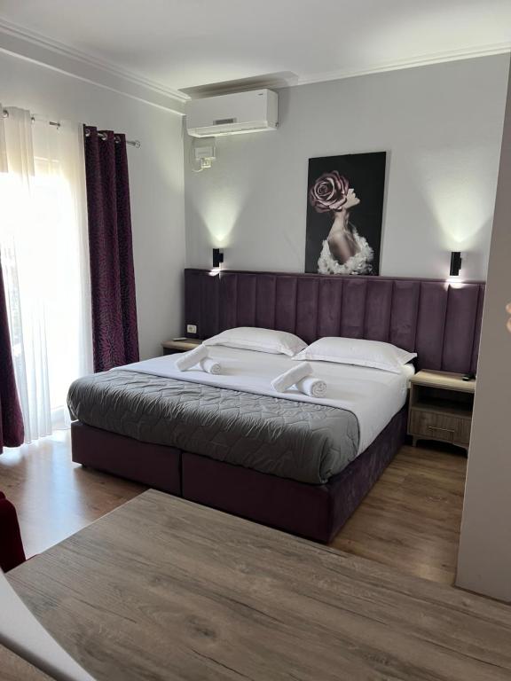 - une chambre avec un grand lit dans l'établissement Hotel Floga, à Shkodër