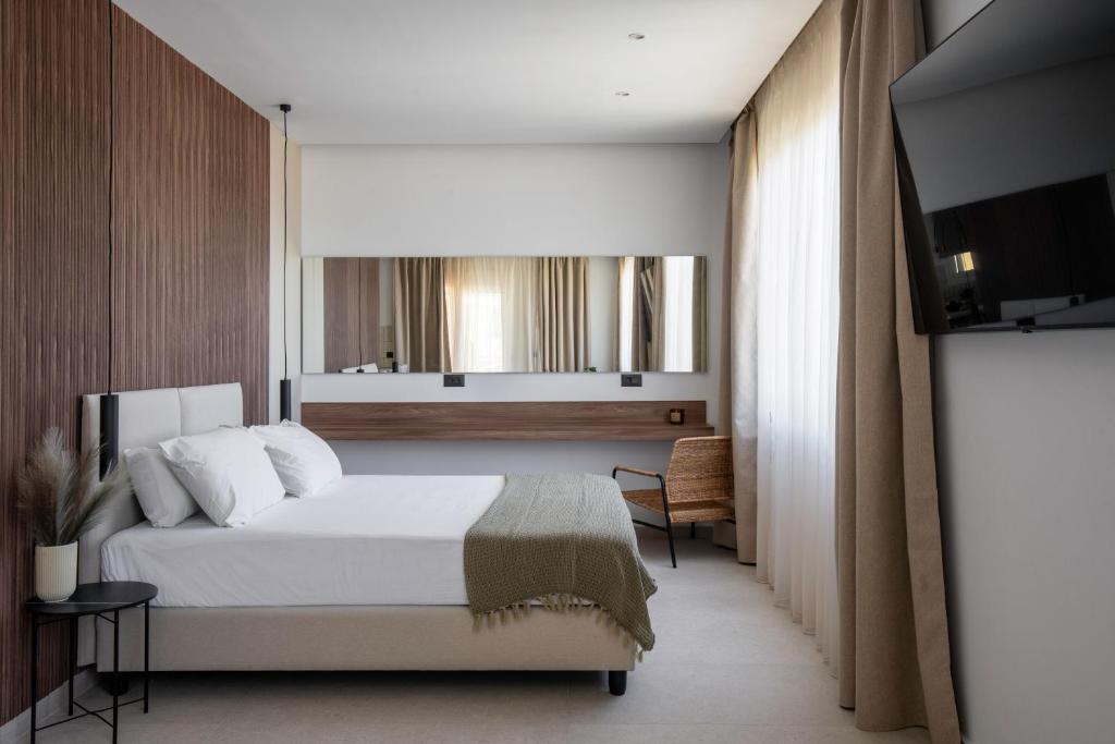sypialnia z łóżkiem i telewizorem w obiekcie Theros Luxury Apartment w mieście Archangelos