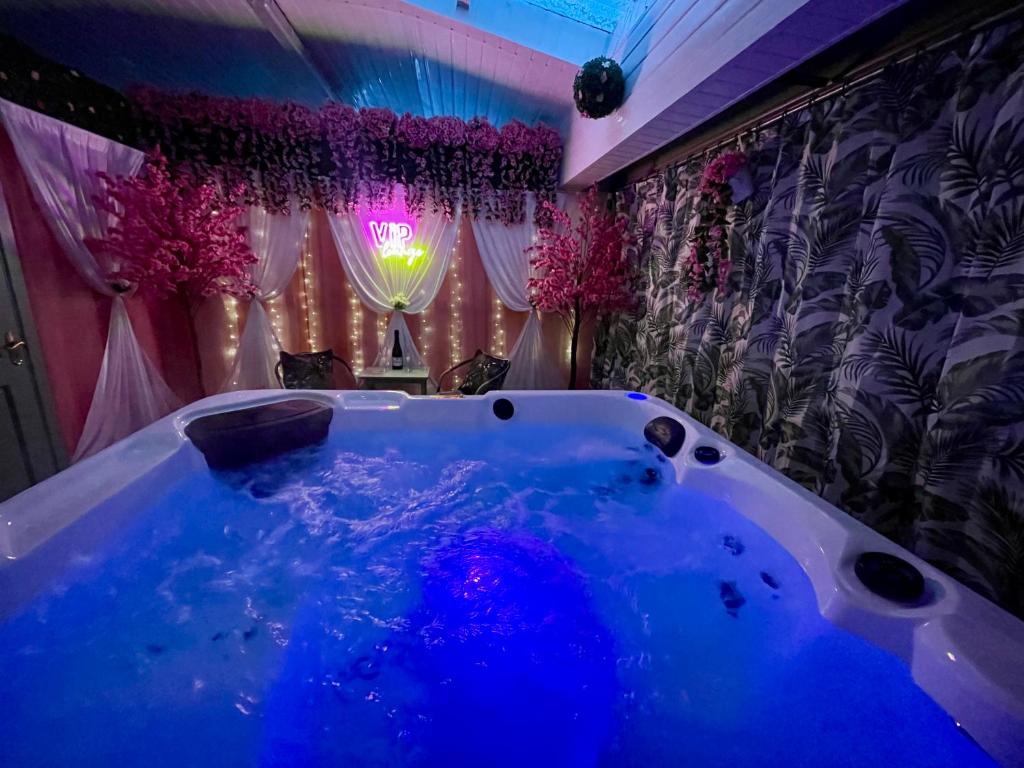 a bath tub in a room with purple curtains at Cleomack View, Annex apartment with Hot Tub in Hilltown
