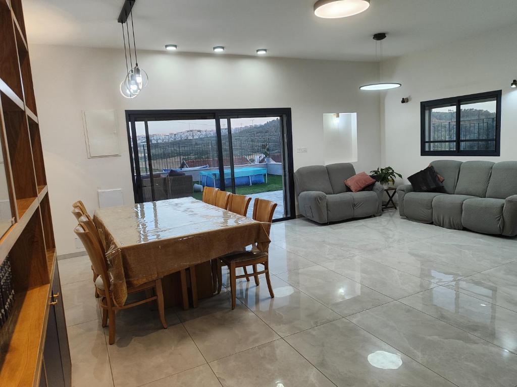 a living room with a table and a couch at וילה כשרה ונוף מטורף בבית שמש in Bet Shemesh