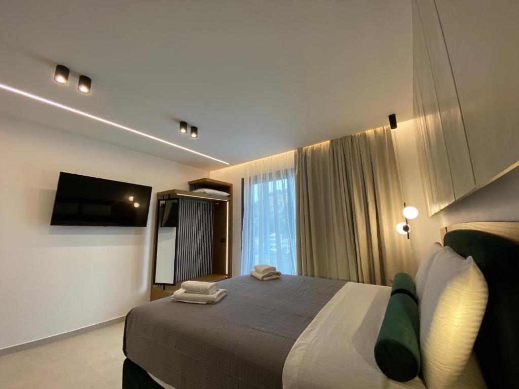 Habitación de hotel con cama y TV en Tramonto Maisonettes & Suites en Parga