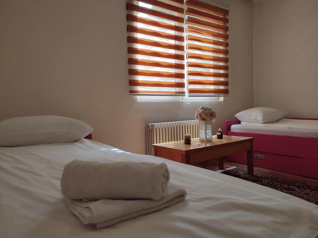 サラエボにあるSarajevo Paradiseのベッドルーム1室(ベッド2台、窓付きテーブル付)