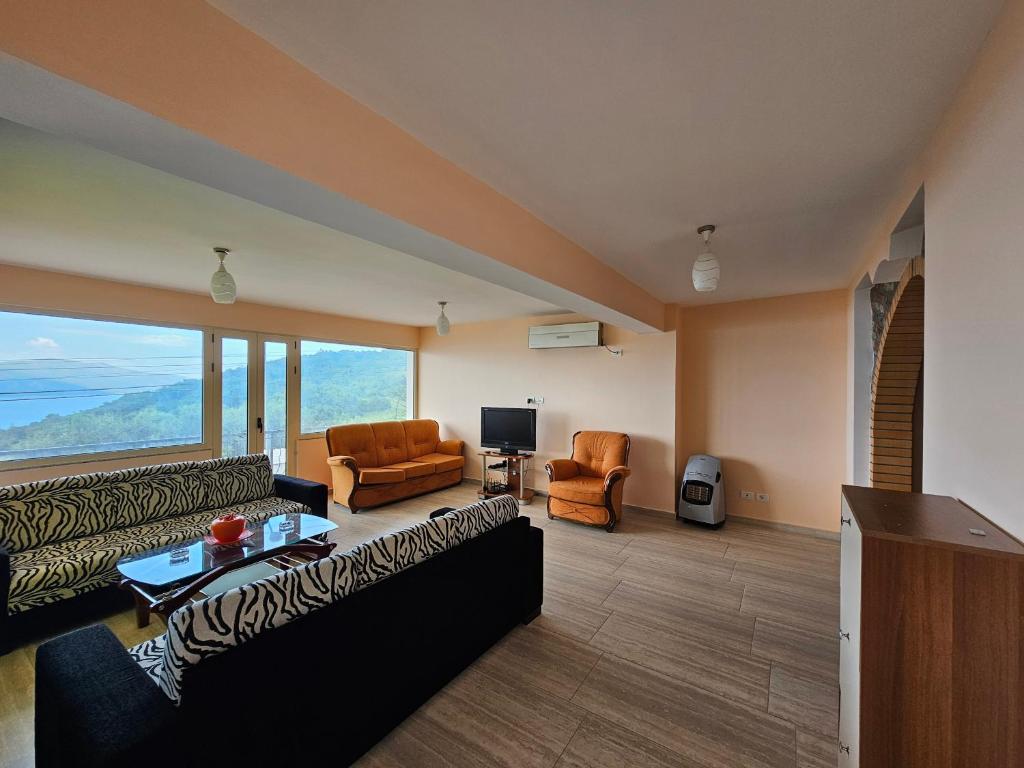 a living room with couches and chairs and a television at Villa Dario in Vlorë