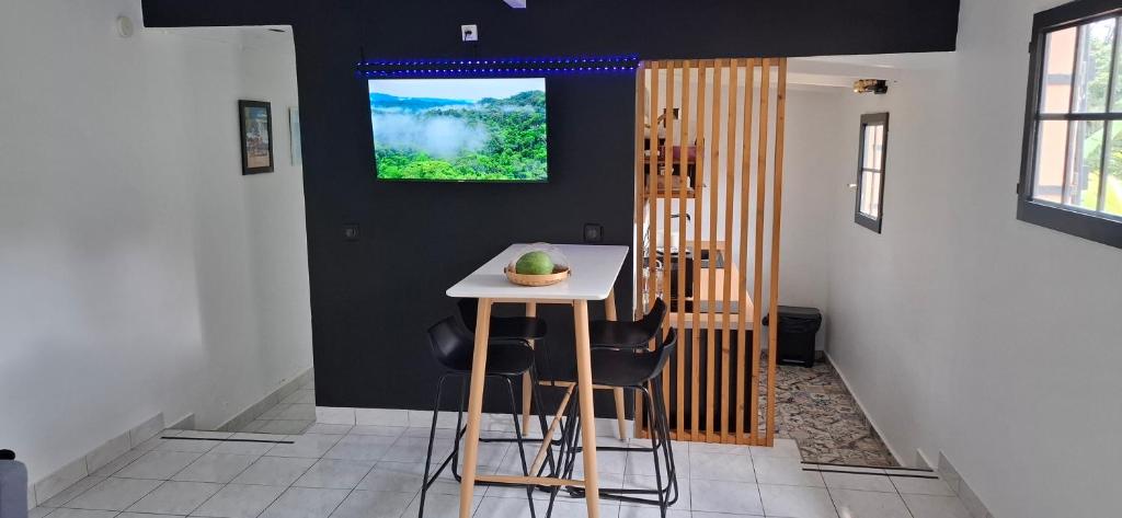 - une cuisine avec une table et des chaises dans la chambre dans l'établissement Le Ptit Gibs, à Petit-Bourg