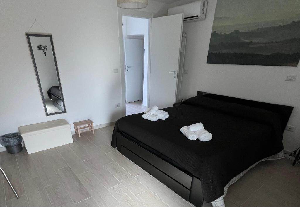 Un dormitorio con una cama negra con toallas. en Alla Posta Matrimoniale Relax, en Posta Fibreno