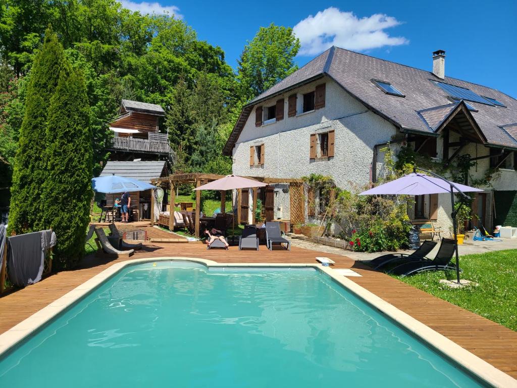 a swimming pool in front of a house at L'oree des Bornes-appartement avec piscine in Évires