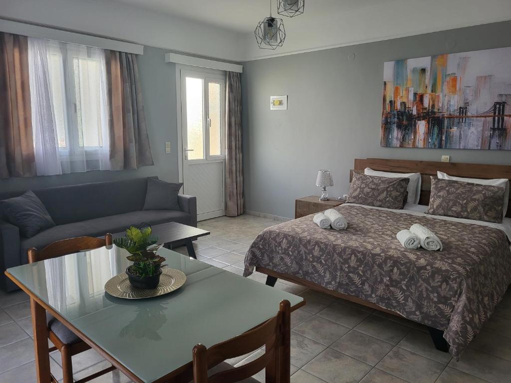 a bedroom with a bed and a table and a couch at DIMITRA STUDIOS in Lefkada Town