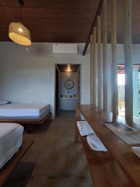 Zimmer mit 2 Betten und einem Holztisch in der Unterkunft Casa Carol - Macapá Paradise in Luis Correia