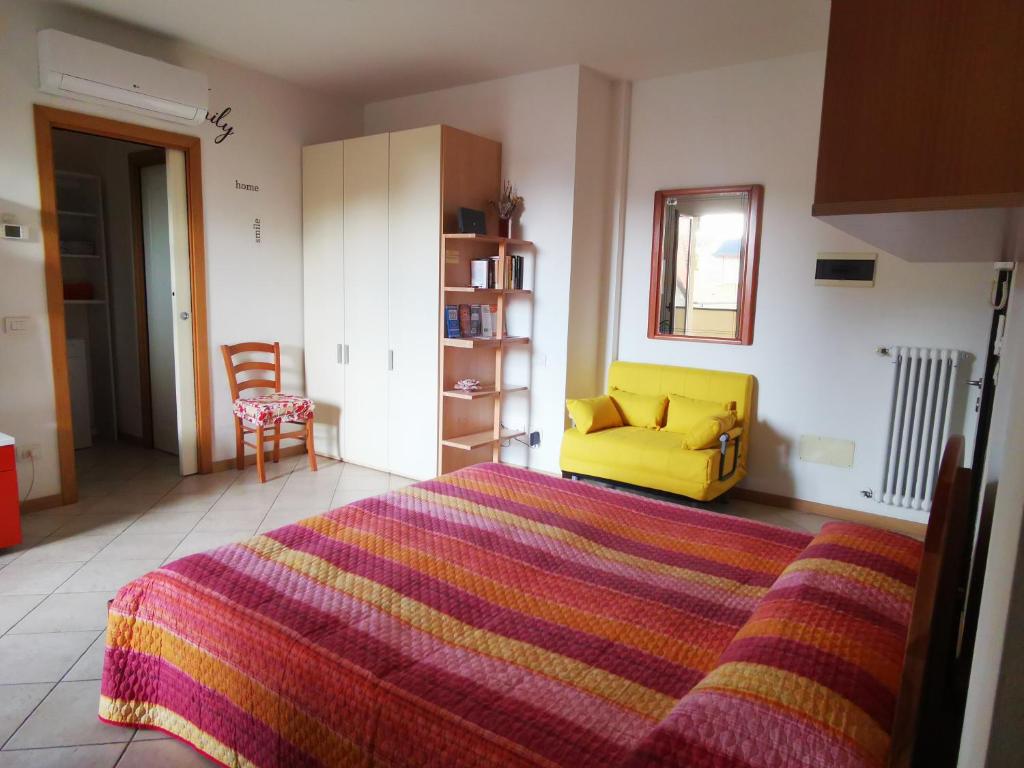 um quarto com uma cama e um sofá amarelo em Marechiaro em Rimini