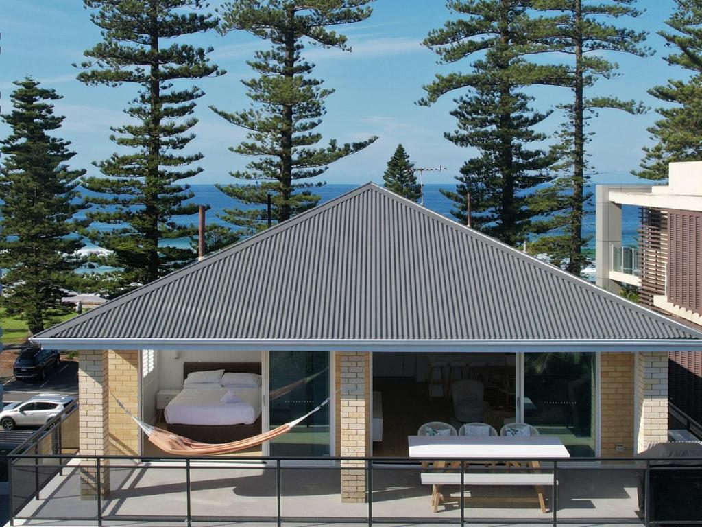 uma casa com uma rede fora dela em Stunning 2-Bed Coastal Pad Across From the Beach em Sydney