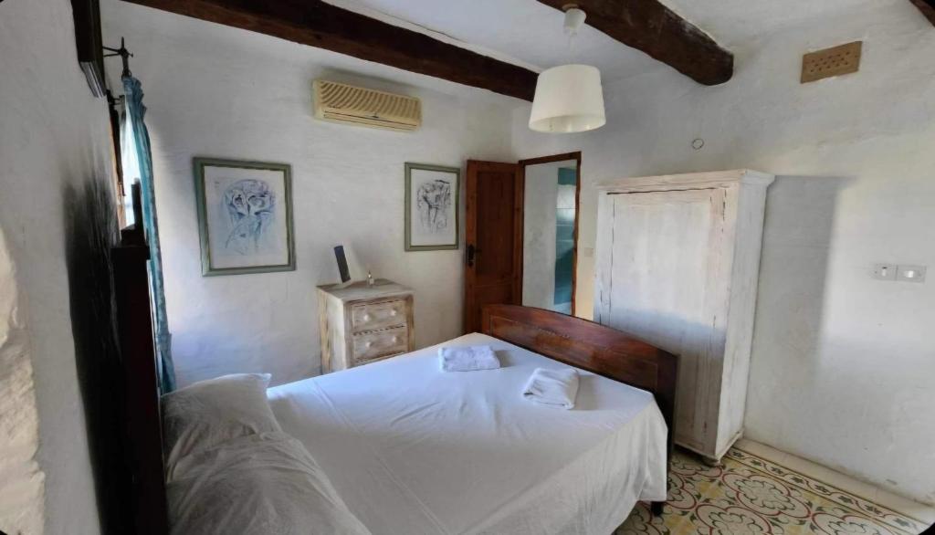 - une chambre avec un lit blanc et un miroir dans l'établissement Sannat Hills Farmhouse, à Sannat