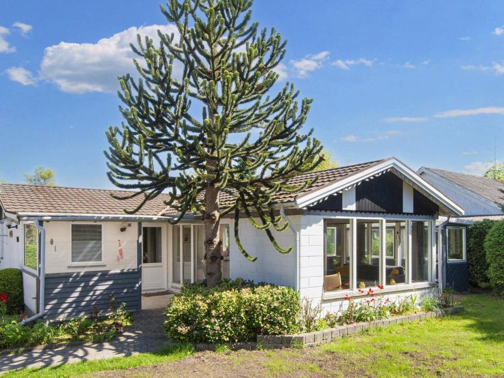a small white house with a tree in the yard at 4 star holiday home in Glesborg-By Traum in Glesborg