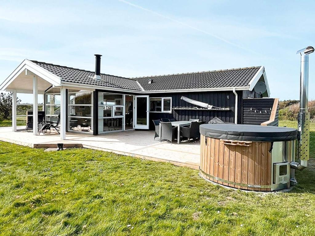 a house with a grill in a yard at 6 person holiday home in Hjørring-By Traum in Lønstrup