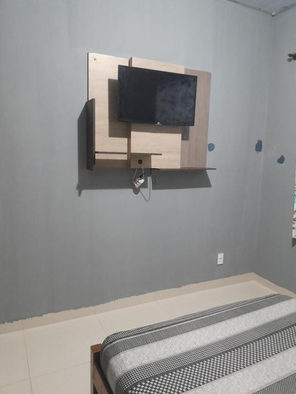 um quarto com uma televisão de ecrã plano na parede em CASA RONDÔNIA RURAL SHOW em Ji-Paraná
