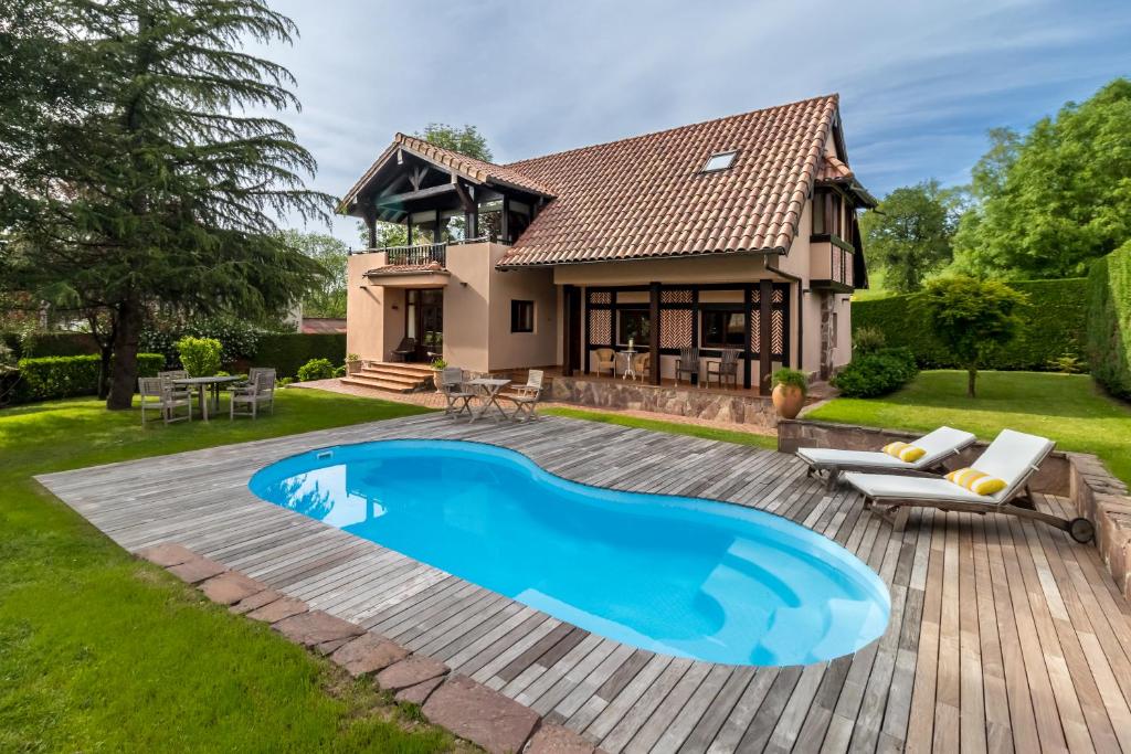 a backyard with a swimming pool and a house at Casa Velasco in Esles