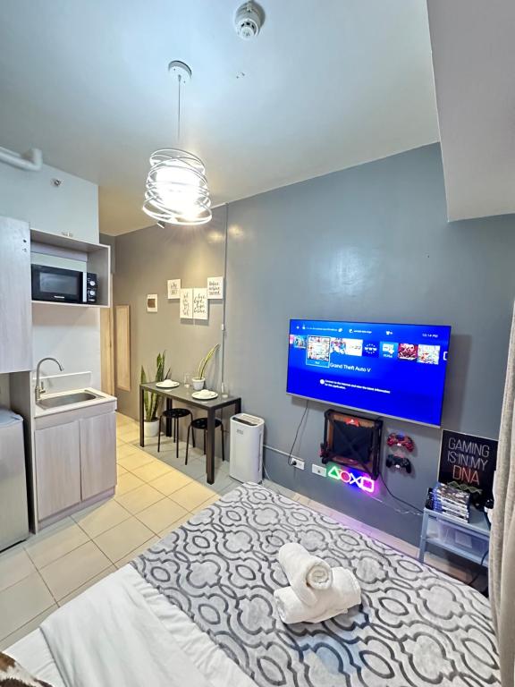a kitchen and living room with a large tv on the wall at Affordable Staycation Studio Rooms Edsa Shaw MRT Greenfield Near Ortigas and Pasig F Residences and Urban deca Shaw in Manila