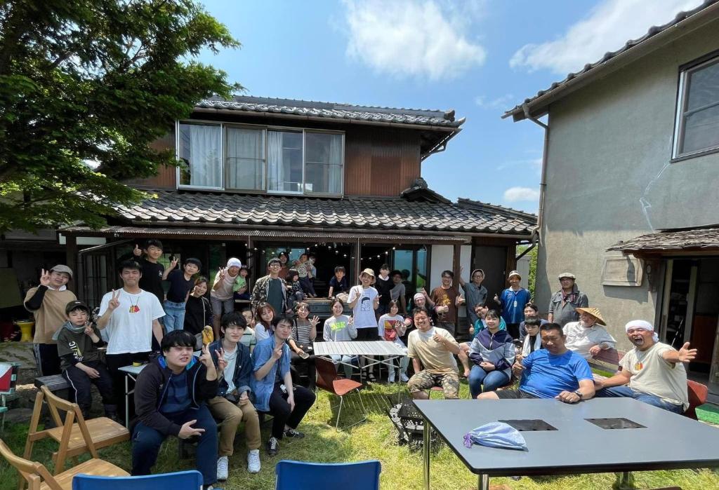 um grupo de pessoas em pé em frente a uma casa em Obasute Guesthouse Nakaraya em Chikuma