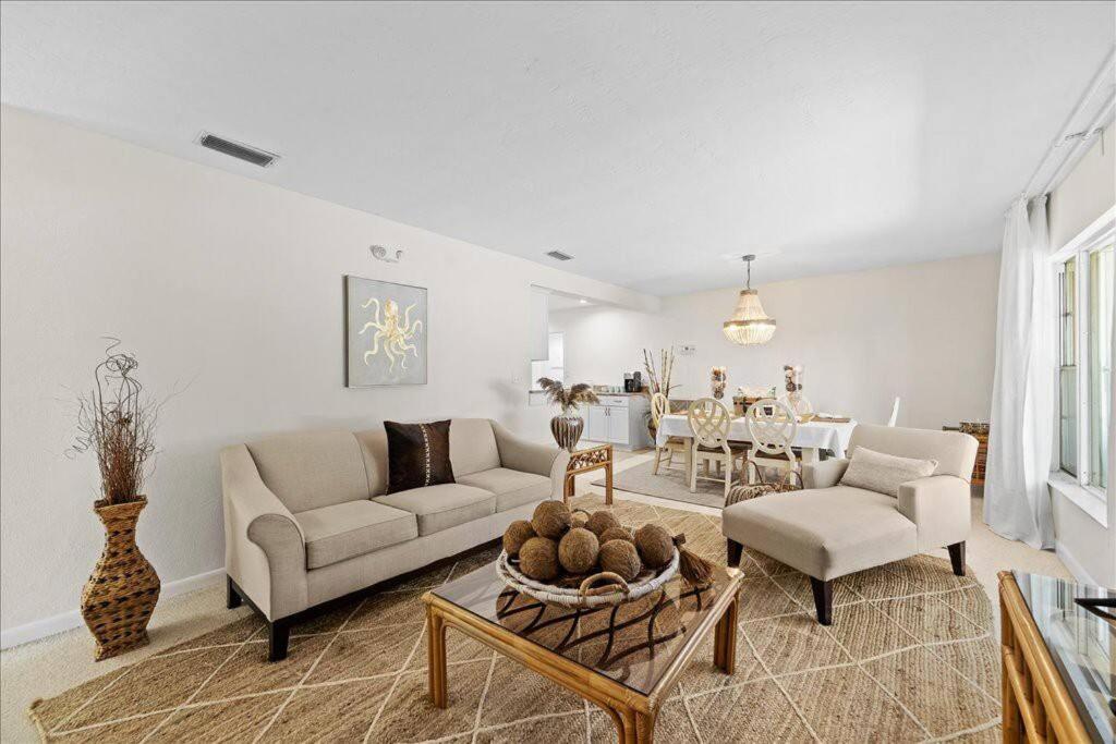 a living room with a couch and a table at Coastal Chic Home, Walk to Beach in Cocoa Beach