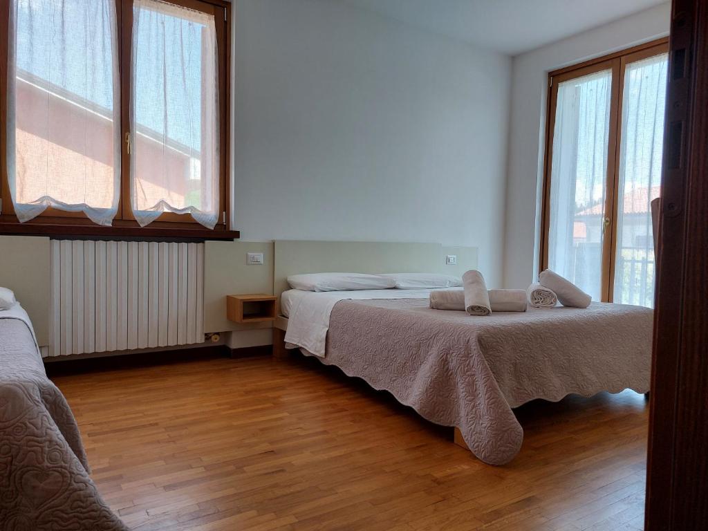 sypialnia z 2 łóżkami i 2 oknami w obiekcie Le Betulle Affittacamere w mieście Sona