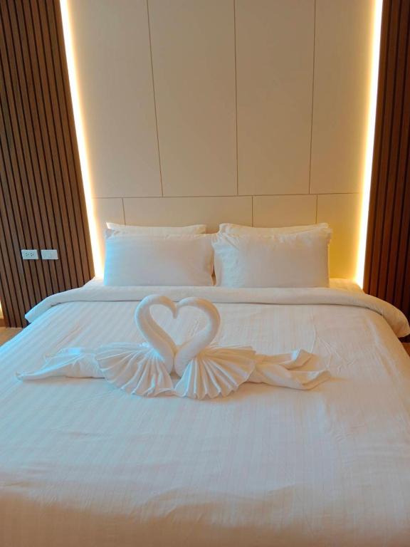 a white bed with two heart shaped wings on it at Tommy Resort2 in Haad Rin