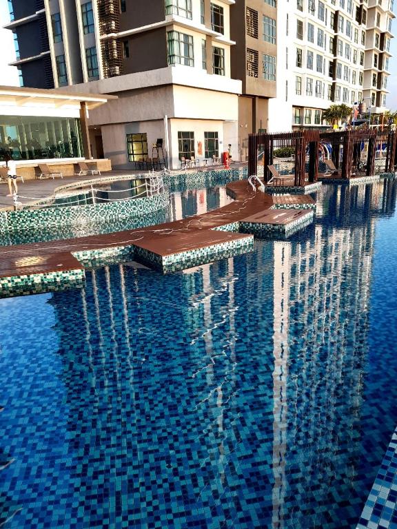 a large swimming pool with blue water and buildings at Kuantan City 188 in Kuantan