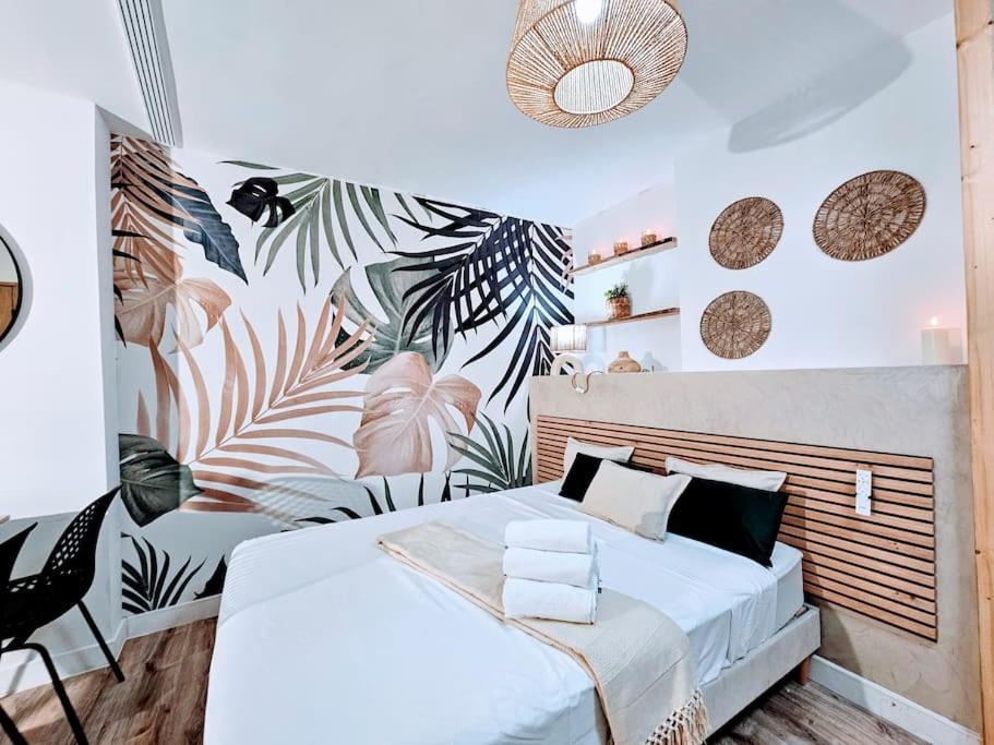 - une chambre avec un grand lit recouvert de plantes dans l'établissement Cocon Pure Détente Balnéo Jacuzzi, à Saint-Étienne