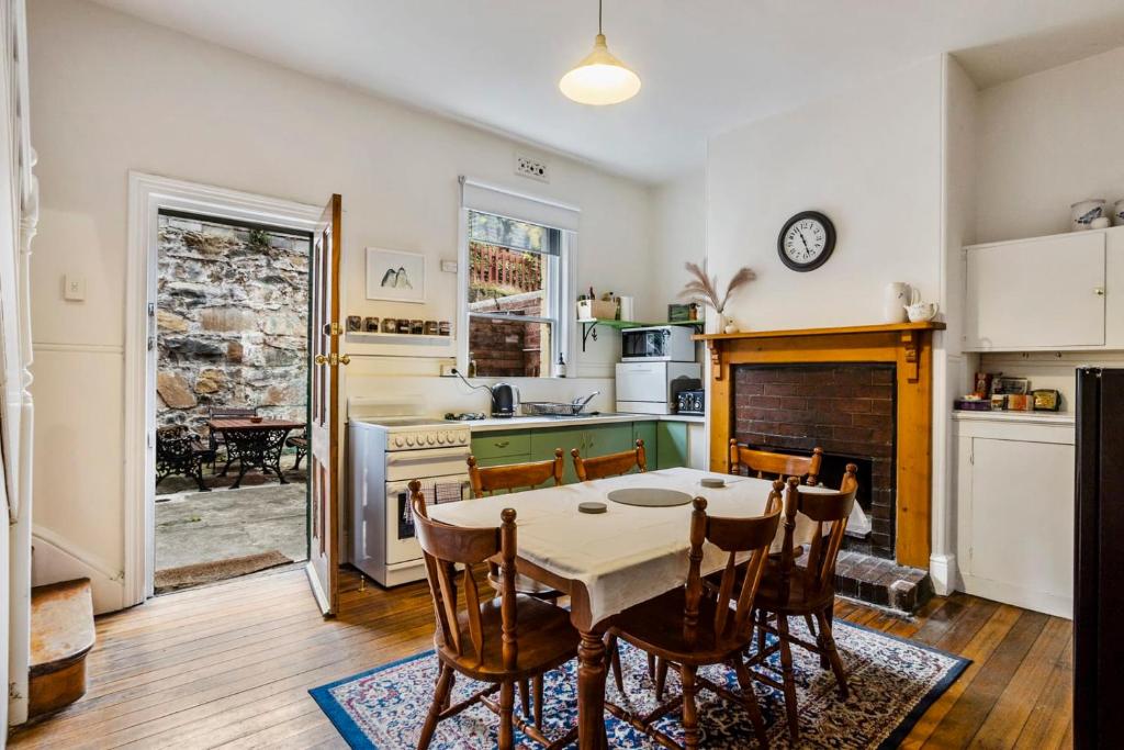 Una cocina con una mesa y sillas en una habitación. en Karkalla Terrace - Explore Hobart's Historic Heart, en Sandy Bay