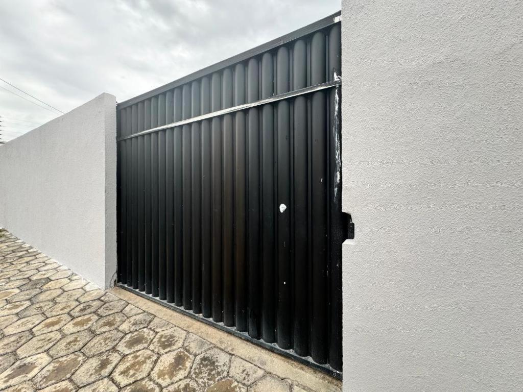 a black gate on the side of a building at Ap no Derby com Garagem AC in Sobral
