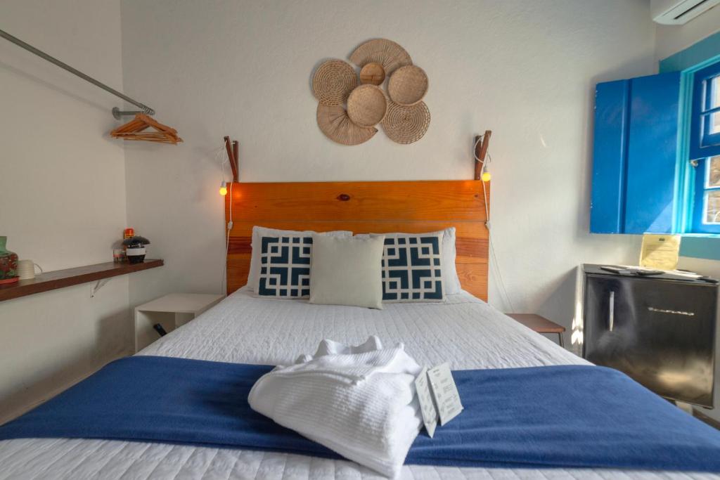 a bedroom with a large bed with blue and white sheets at Casas do Pátio Pousada & Bar in Paraty