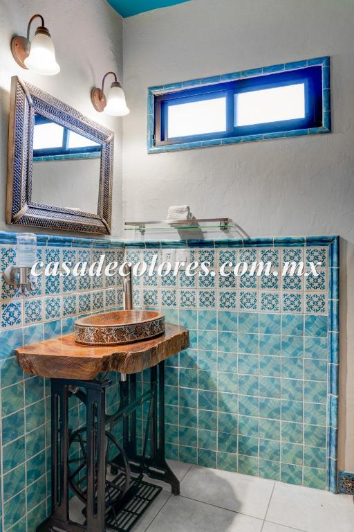 W łazience znajduje się umywalka i lustro. w obiekcie Casa de Colores w mieście Guanajuato