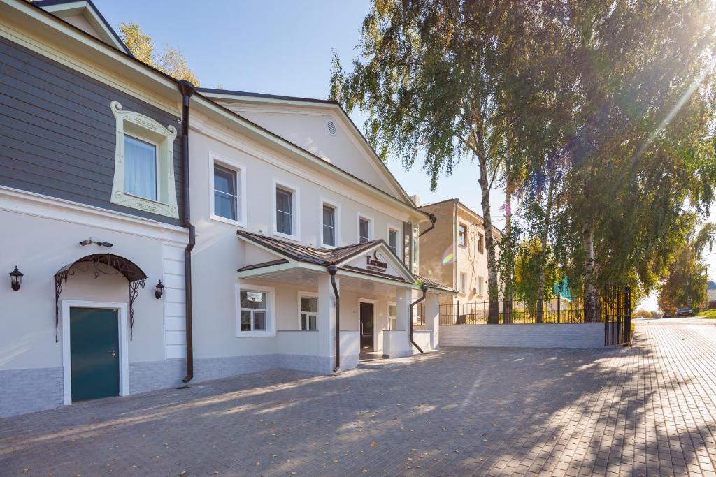 una calle vacía frente a un edificio blanco en Hotel Yesenin en Murom