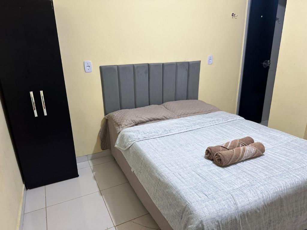 Un dormitorio con una cama con una toalla. en Capim dourado privativo a minutos do aeroporto, en Palmas