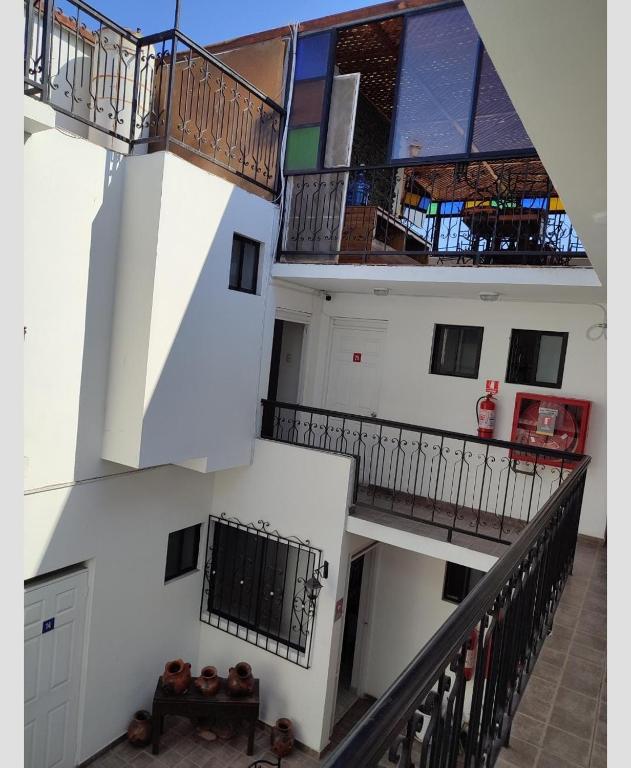 a building with two floors and a staircase with windows at Alto Chinchorro Hostel in Arica