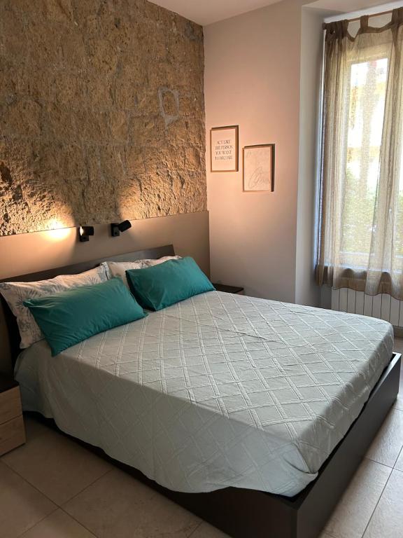 una camera da letto con un grande letto con cuscini blu di Mirea Garden apartment a Napoli