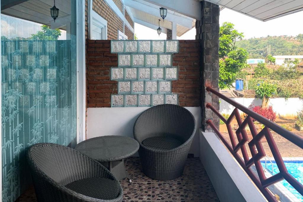 - Balcón con 2 sillas y mesa en Urbanview Hotel Villa Q Gisting en Banjarnegeri
