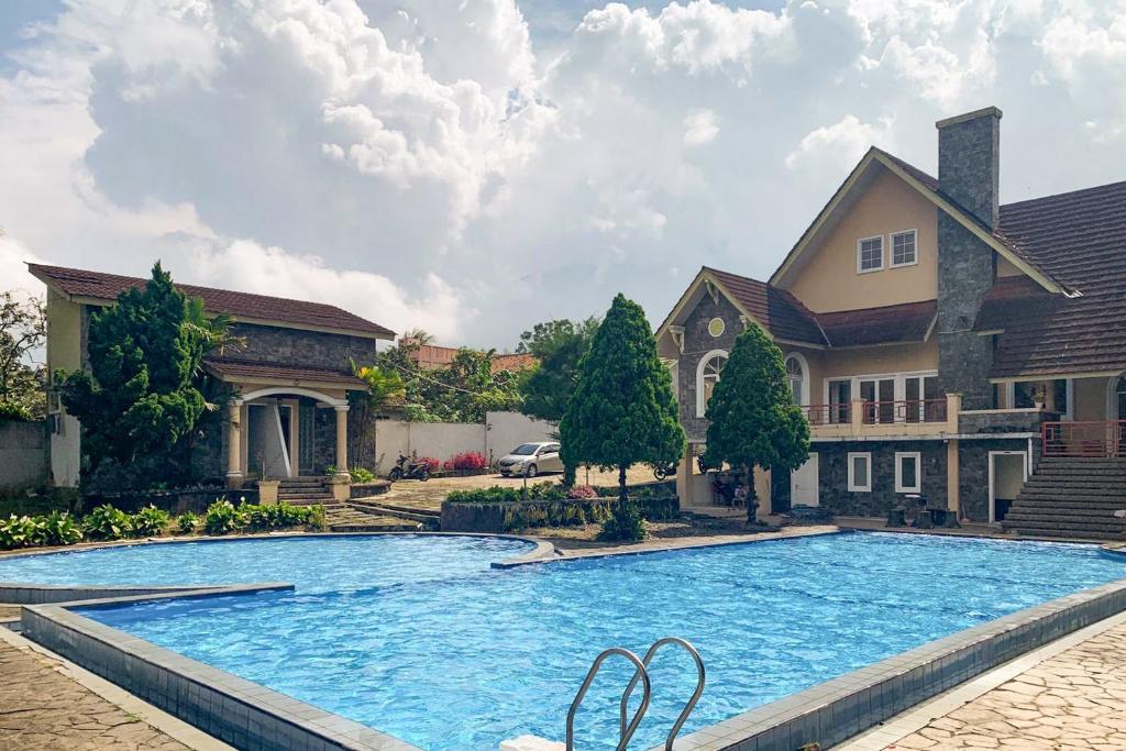 a large swimming pool in front of a house at Urbanview Hotel Villa Q Gisting by RedDoorz in Banjarnegeri