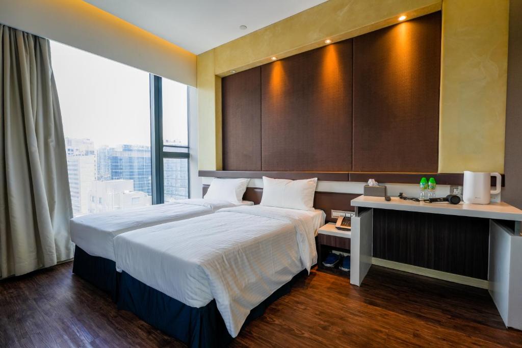 ein Hotelzimmer mit einem großen Bett und einem Schreibtisch in der Unterkunft 盛世酒店 Epoch Hotel in Hongkong