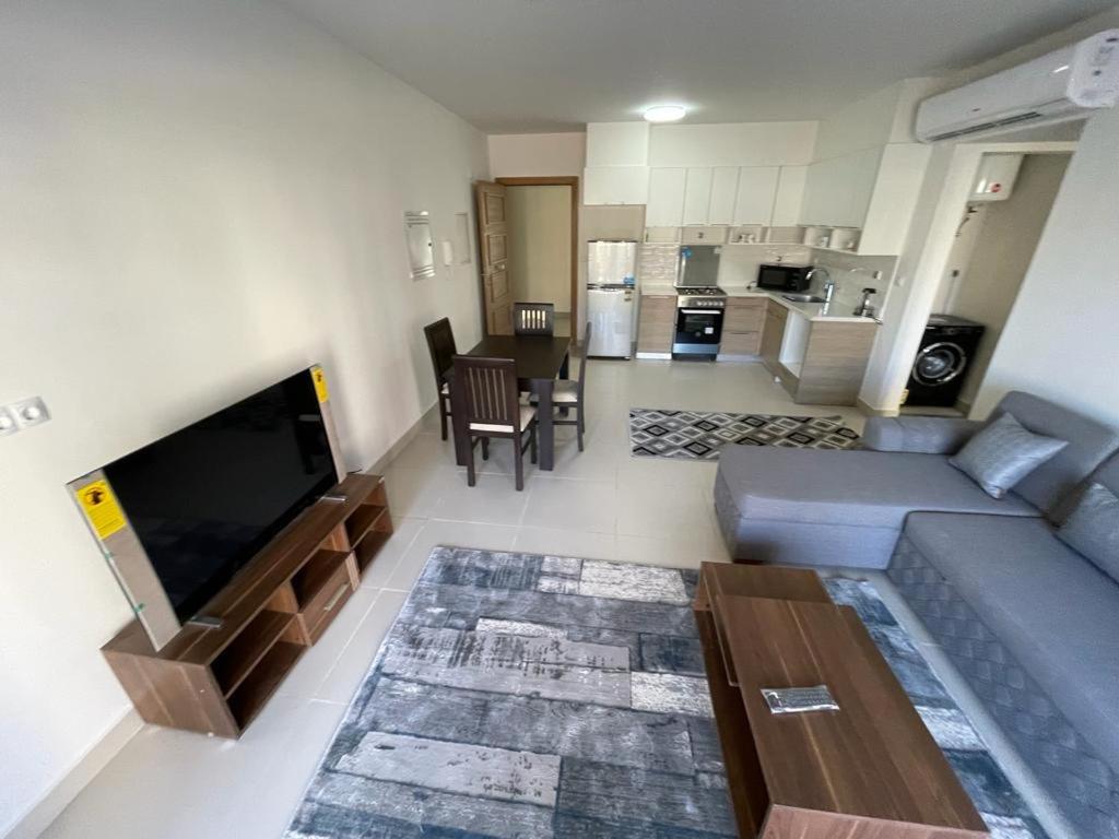 a living room with a couch and a tv and a kitchen at Ground chalet 2 bedrooms marina 2 marassi Direct to swimming pool in El Alamein