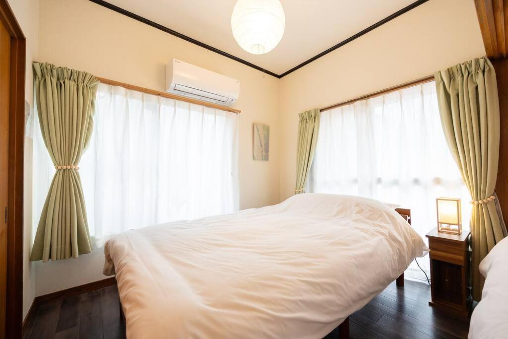 a bedroom with a white bed and a window at New! Kamata close Haneda AP - Traditional & Hot Spring in Tokyo