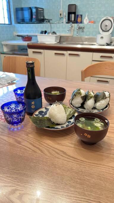 a table with bowls of food and a bottle of wine at New! Kamata close Haneda AP - Traditional & Hot Spring in Tokyo