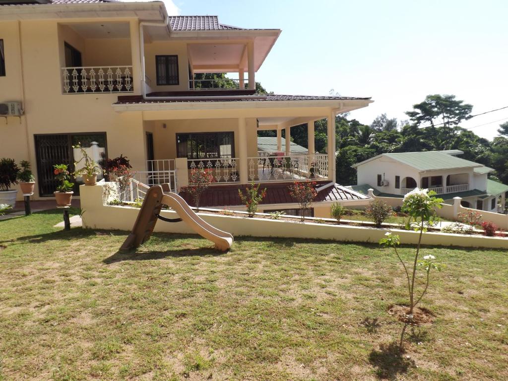 uma casa com um parque infantil em frente em Charlotte Villa em Takamaka