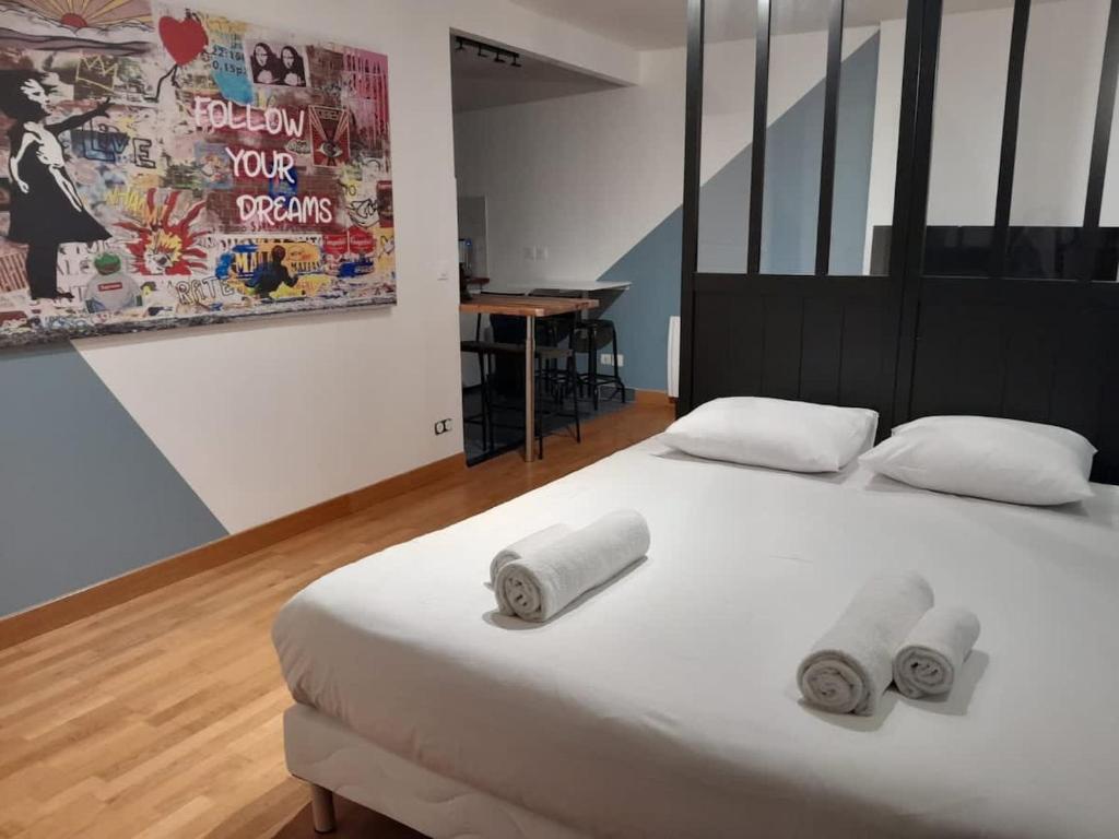 una camera da letto con un letto con tre asciugamani arrotolati di Studio Marin ad Arcueil
