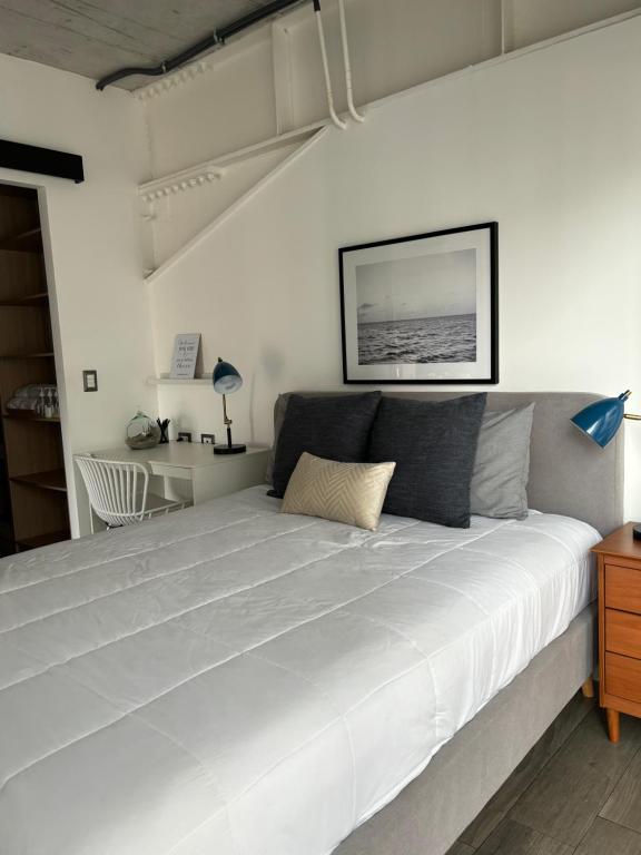 - un grand lit blanc dans une chambre blanche dans l'établissement Apartamento moderno 1 habitación y 1 baño, área Cayalá Embajada USA CASH ONLY, à Guatemala