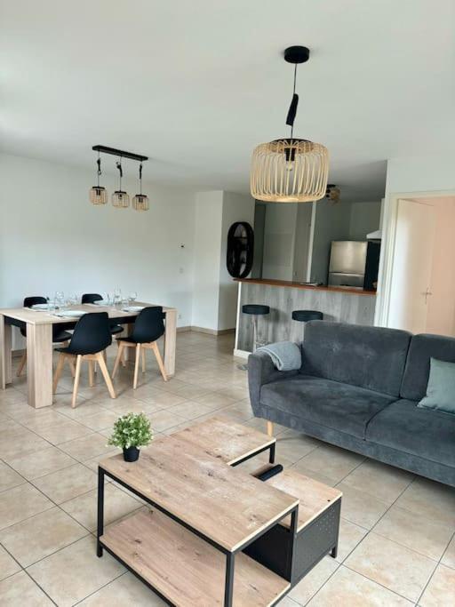 un salon avec un canapé et une table dans l'établissement T3 - Spacieux et au calme - Avec jardin privatif, à Saint-Laurent-de-Médoc