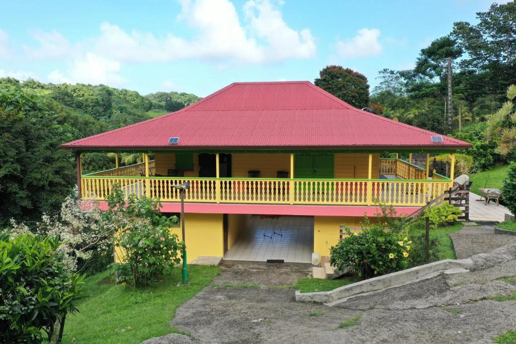uma casa amarela e vermelha com um telhado vermelho em Maison de 2 chambres avec terrasse amenagee et wifi a Gros Morne em Gros-Morne