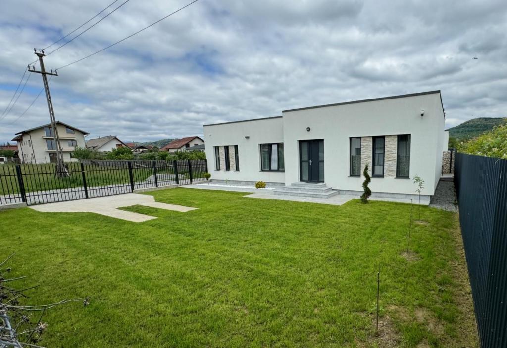 a white house with a large yard at Casa Maya in Curtea de Argeş