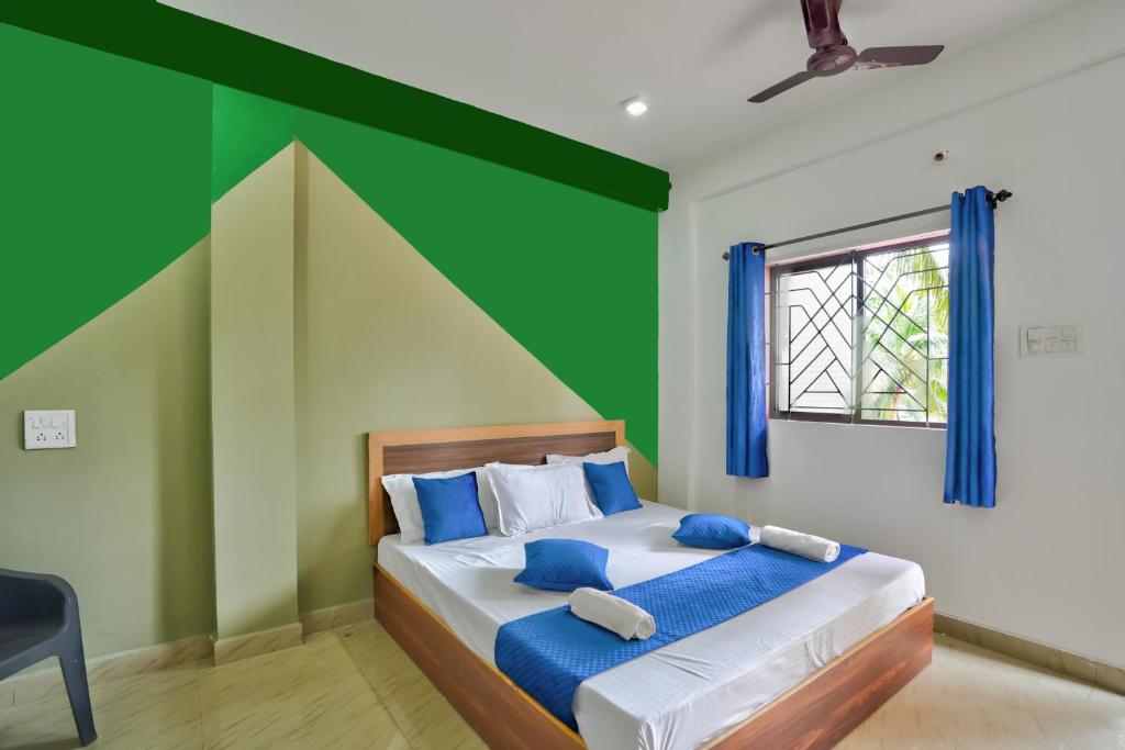 a bedroom with a bed with a green wall at Little Beach Home Stay at Calangute in Calangute